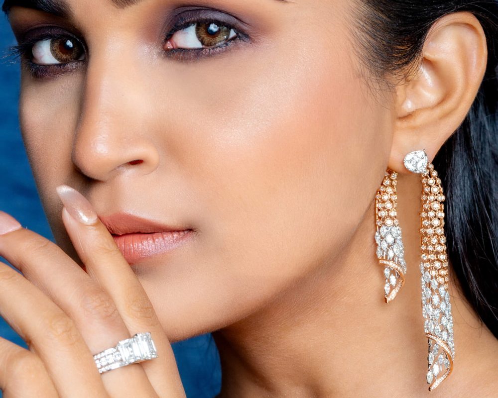 Side view of woman's face wearing earrings and engagement ring from Bespoke Jewels Engagement Rings and Wedding Jewellery.