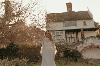 bride model taking a photoshoot infront of a mansion