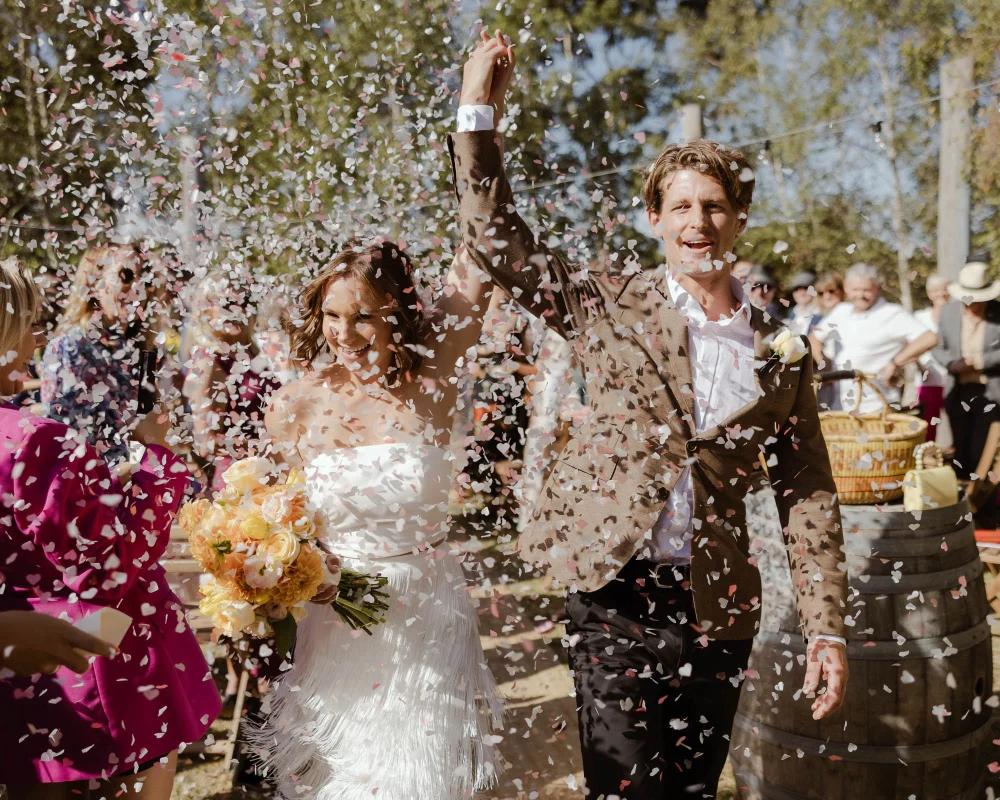 Celebratory wedding moment with bride and groom in confetti, photographed by Dust and Salt Photography Melbourne Wedding Photographer.