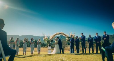 A wedding party posing in front of a majestic mountain background.