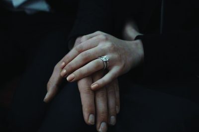 a picture of a hand wearing an engagement ring