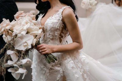 a bride in a wedding dress holding a bouquet of flowers