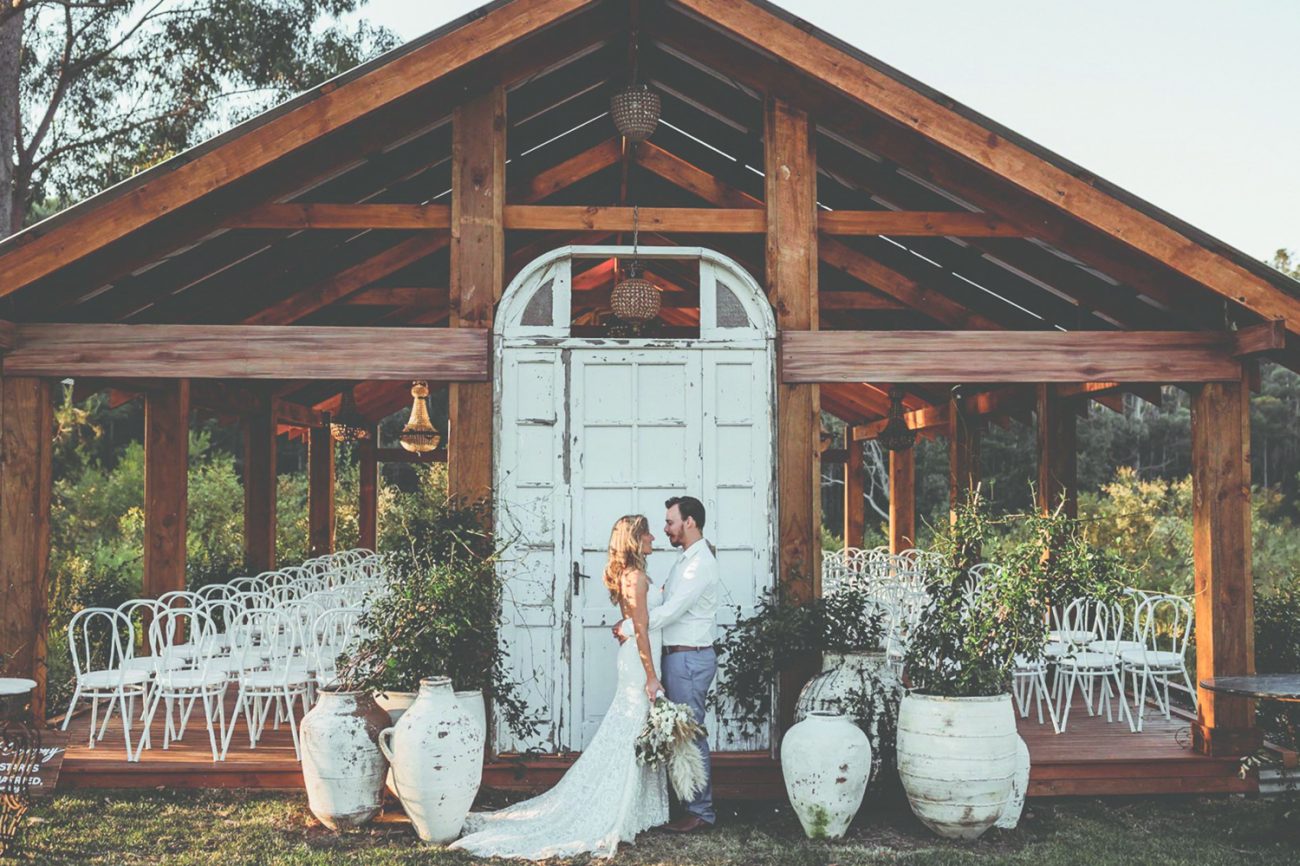 bride and groom standing outdoor covered wedding venue