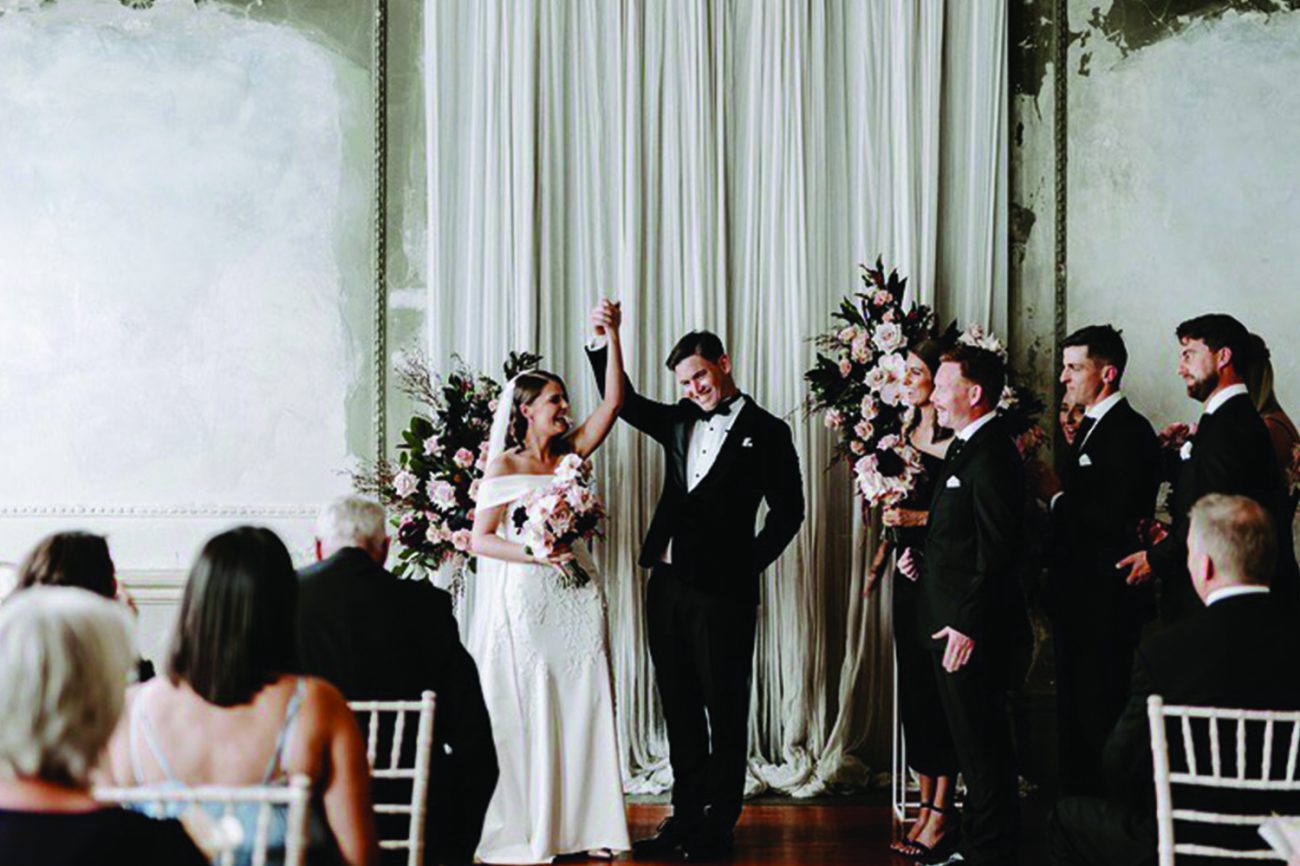 bride and groom raised their hands after their successful wedding ceremony