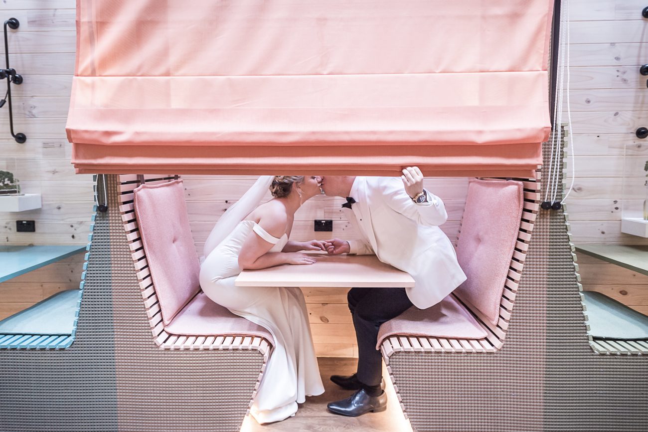 bride and groom kissing in a cafe for a photoshoot