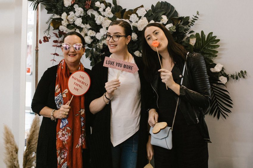 three women enjoyed posing at the photobooth of the wedding expo