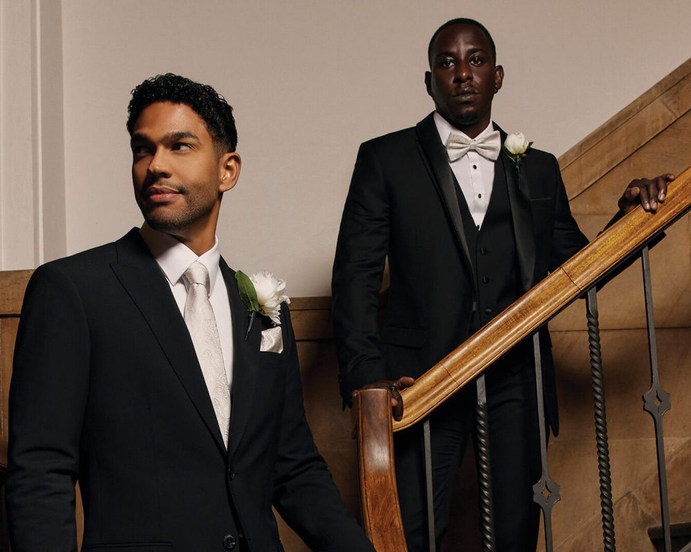 Two gentlemen wearing Politix men's wedding suits in a modern, elegant setting