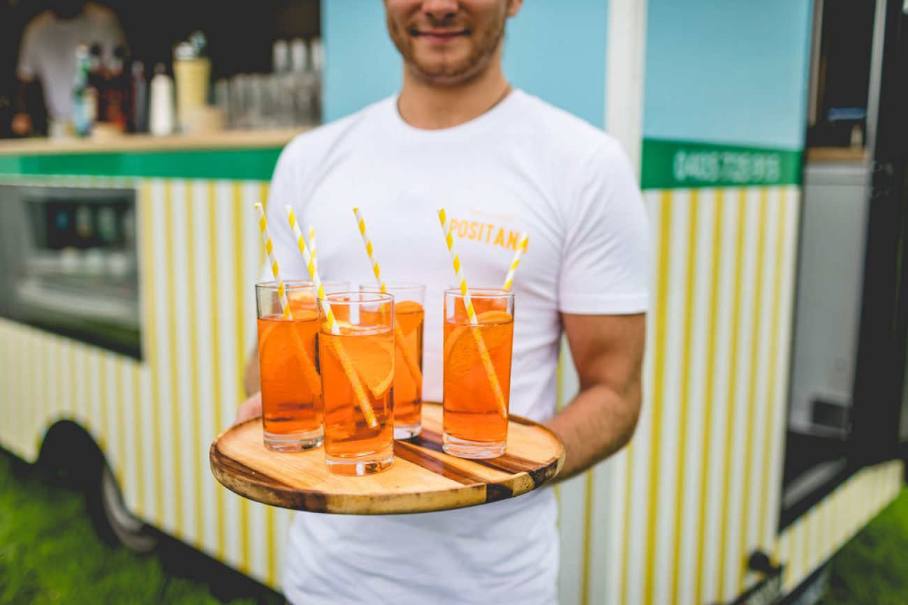 A man showing orange drinks.