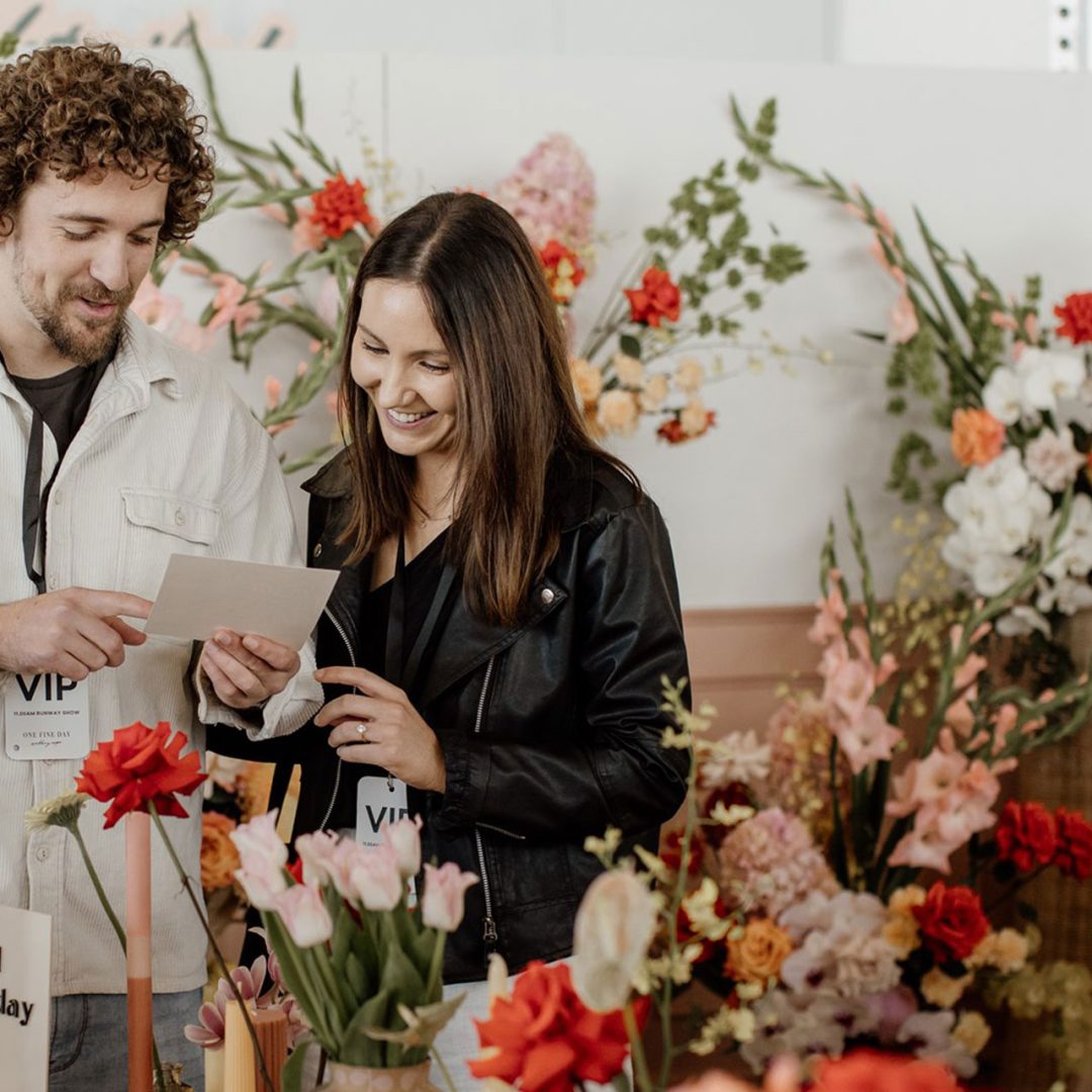 Couple exploring florist and other wedding vendors at the Wedding Expo