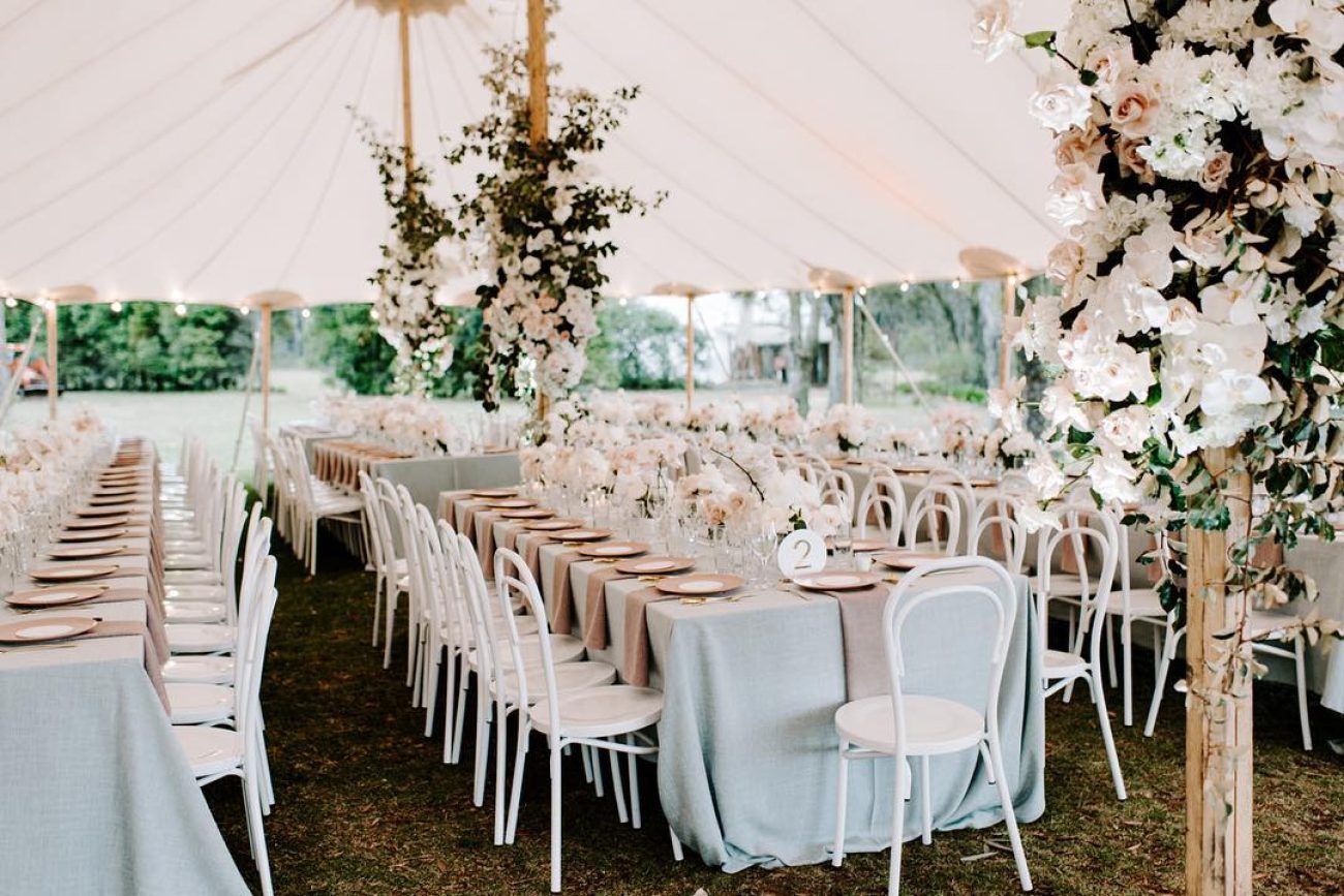 outdoor wedding venue featuring a table grazed in white and nude canvas